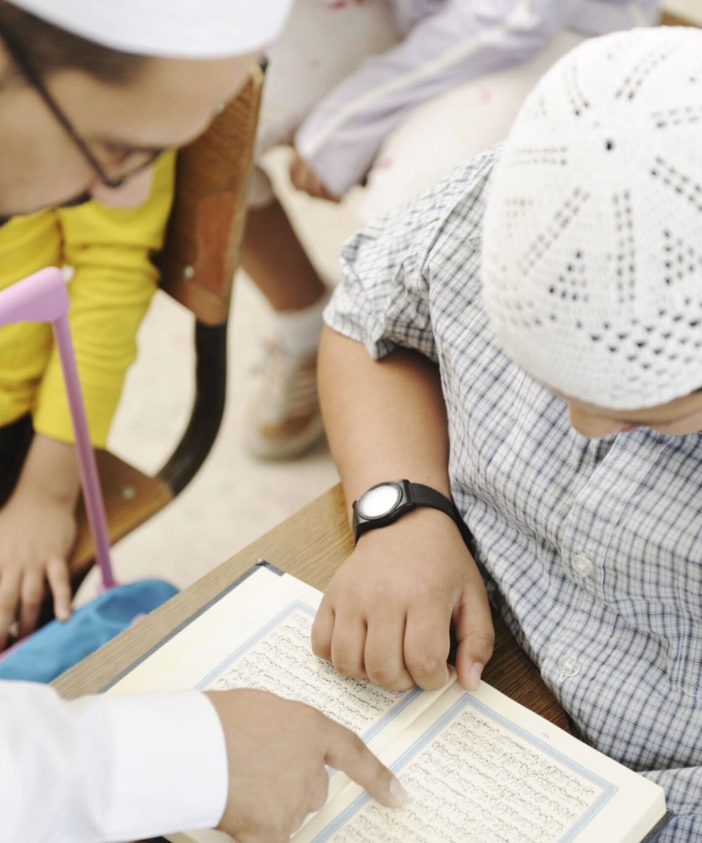 Honeyview_[122259806] Education activities in classroom, Muslim teacher showing Koran to kid