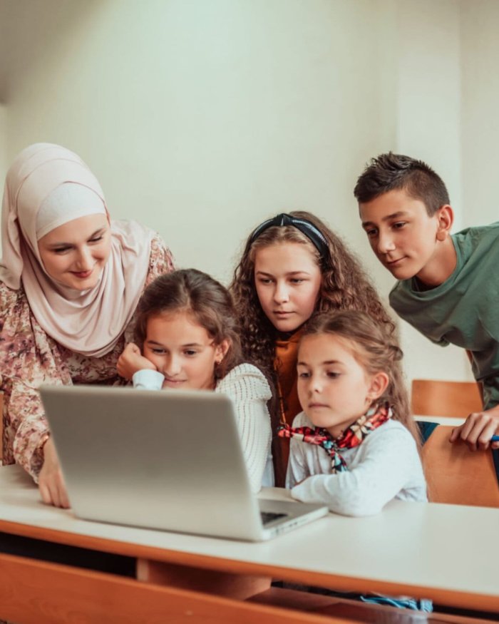 Honeyview_[1340304517] Hijab Muslim Teacher and young students use a laptop in class. Selective focus